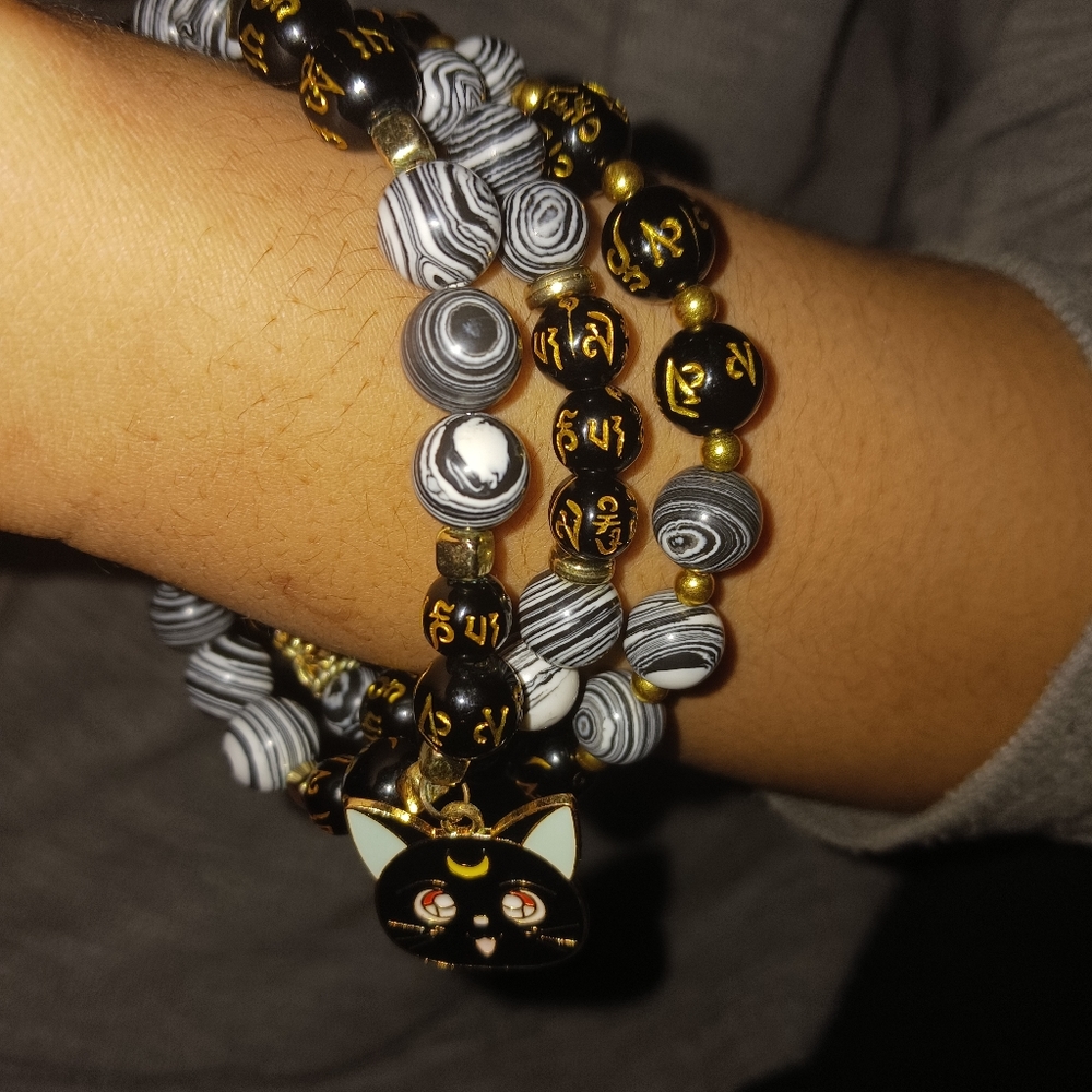 A hand made black and white beaded bracelet set with cat charm